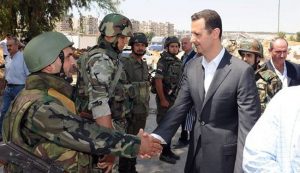 Syrian President Bashar al-Assad (C) shakes hands with a Syrian army soldier in Daraya, southwestern of the capital Damascus on August 1, 2013.